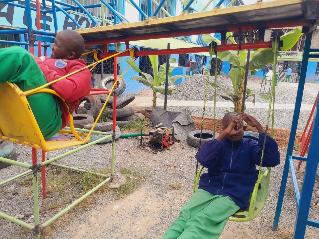 Beneficiaries swinging on the playground at CHDF