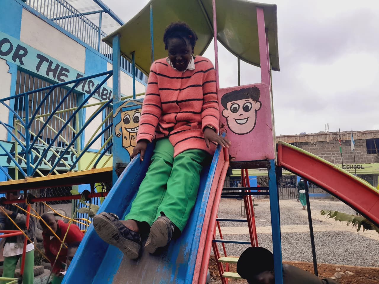 Student sliding down the playground slide at CHDF