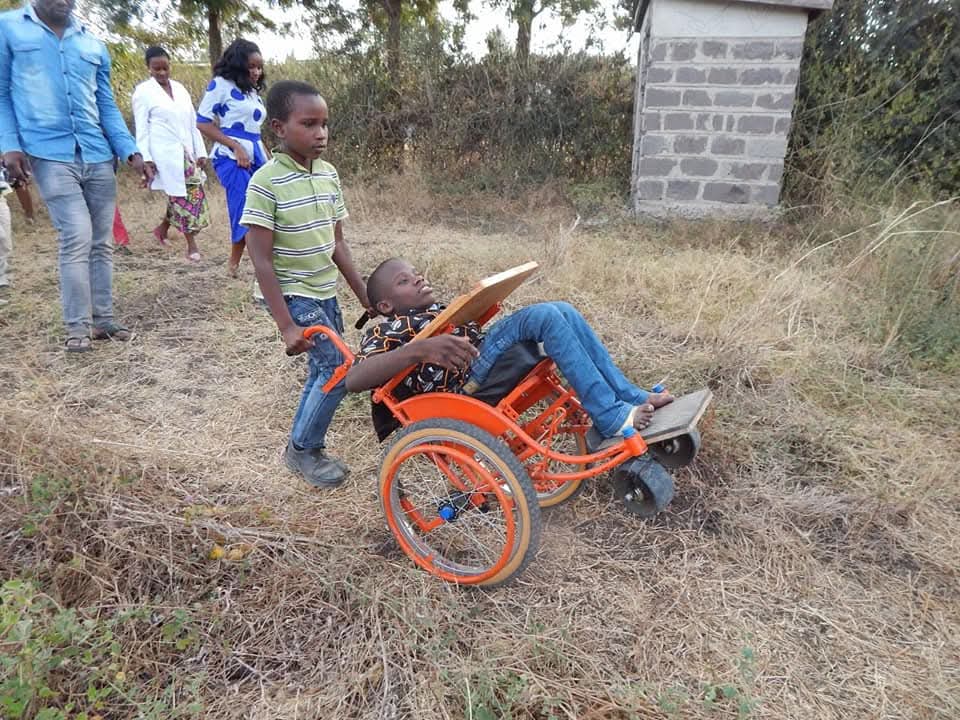 Child assisting friend in wheelchair